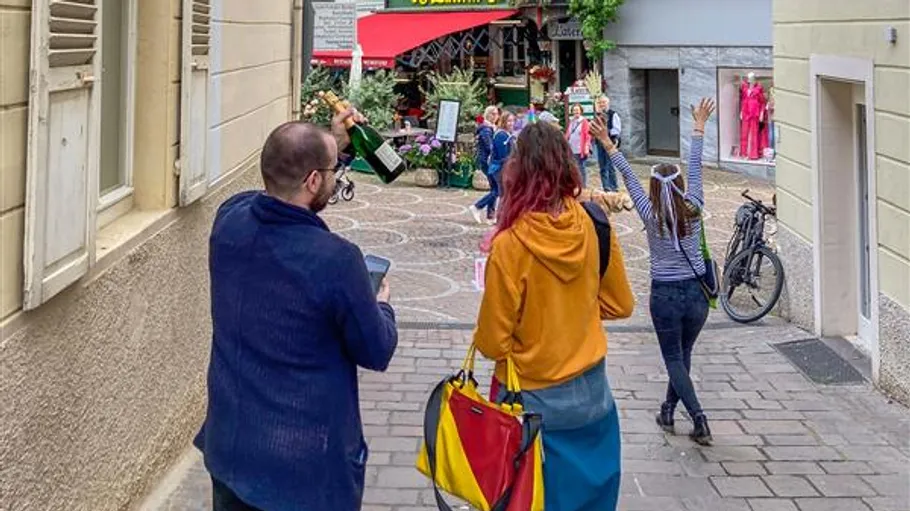 Drei Personen gehen fröhlich in einer Stadtstraße.