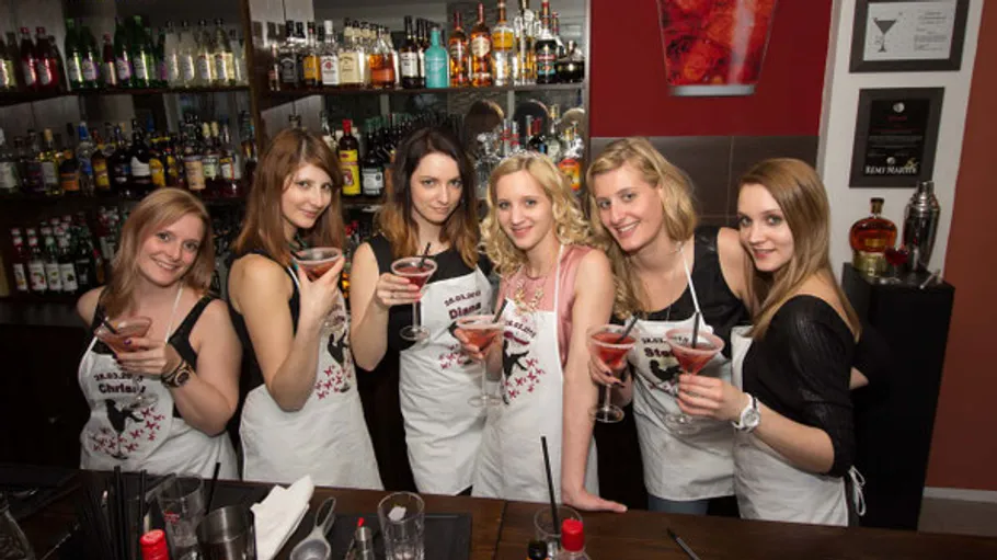 Women holding cocktails in a bar.