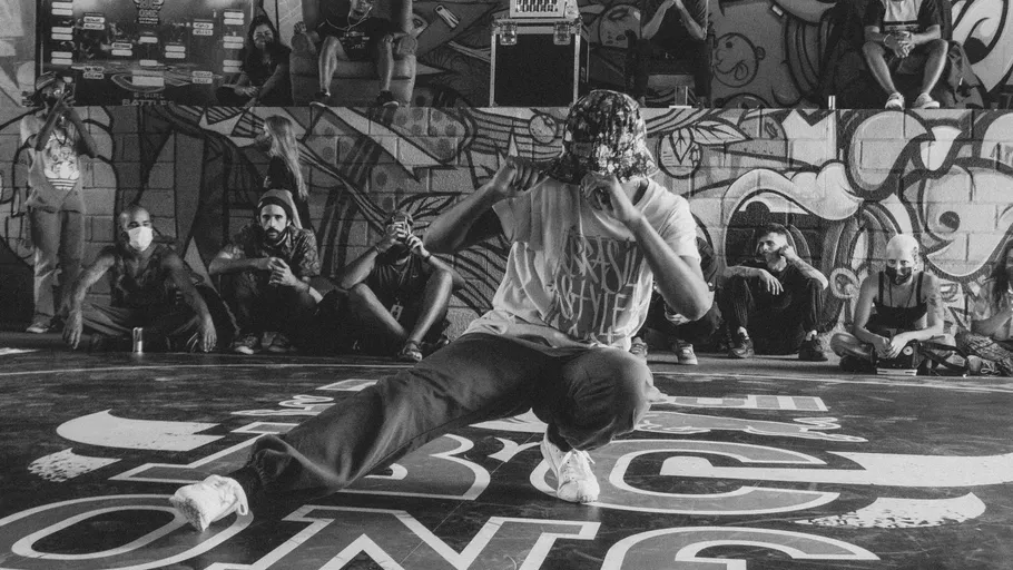 Breakdancer tanzt in graffiti-geschmückter Arena.