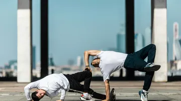 Zwei Männer tanzen Breakdance draußen.