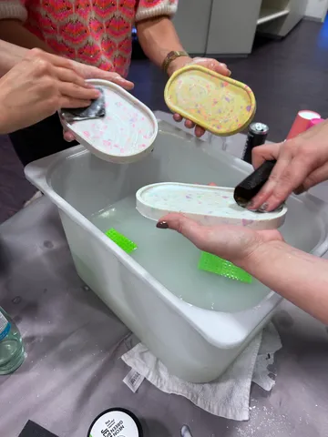 Personen reinigen bunte Tabletts in Wanne.