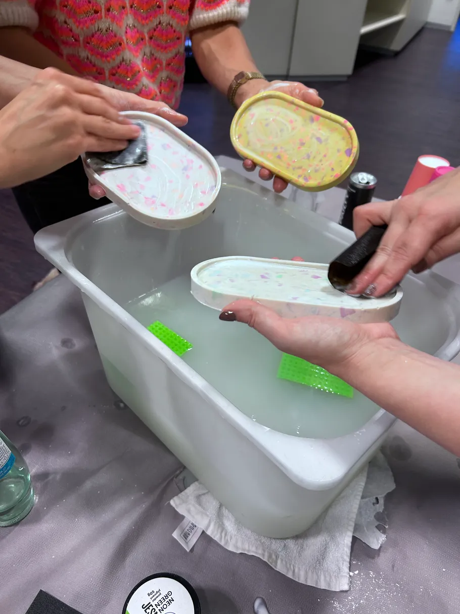 Personen reinigen bunte Tabletts in Wanne.