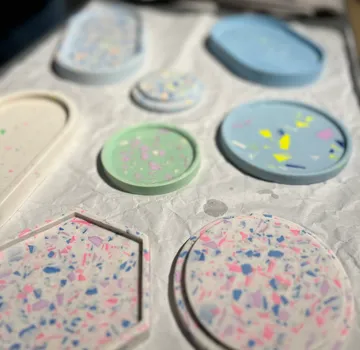 Colorful terrazzo coasters on white fabric.