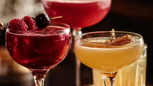 Colorful cocktails in glasses on bar.