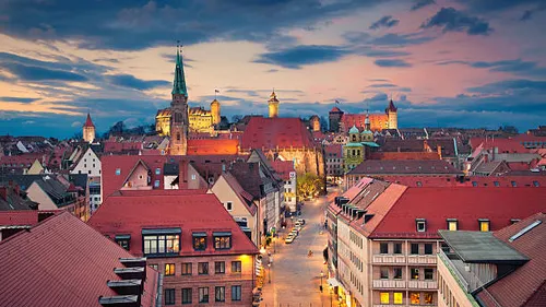 City skyline at sunset with historic buildings.