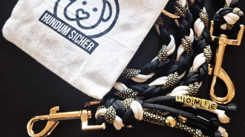 Hundeleine und Tasche mit Logo auf Tisch.