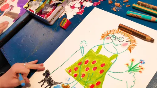 Child's drawing of person and dog on table.