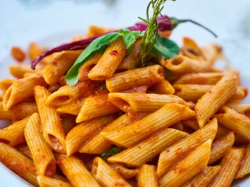 Penne pasta in tomato sauce topped with basil and chilli.