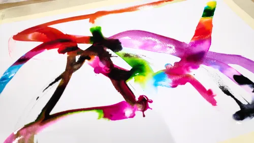Colorful abstract brushstrokes on white paper.