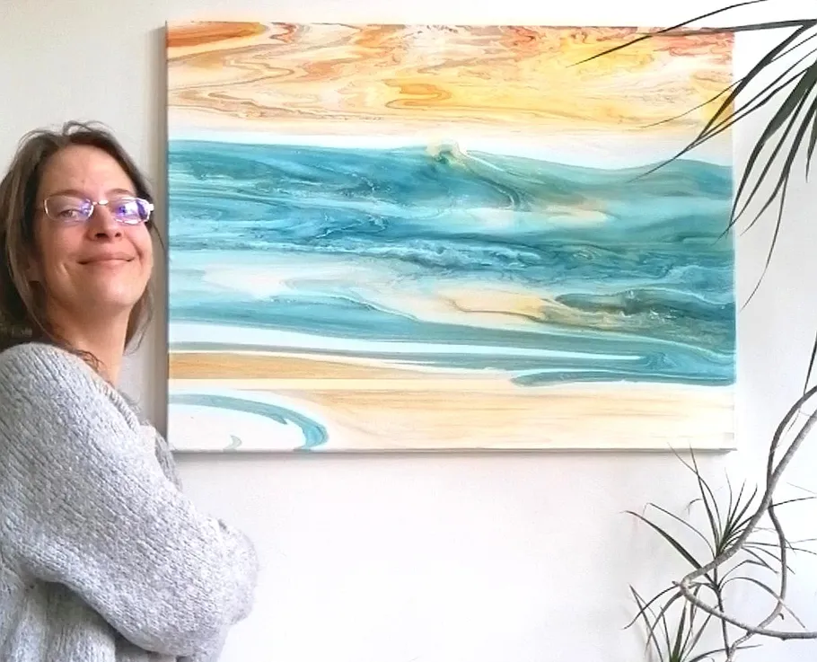 Person lächelt neben abstraktem Ozeanbild.