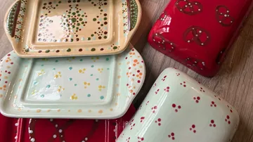 Bunte Keramikgeschirr auf Holztisch.
