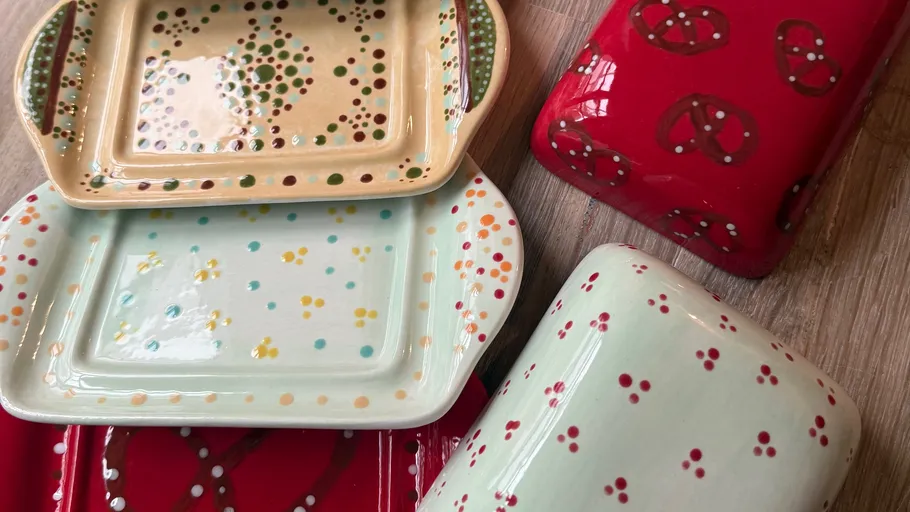 Bunte Keramikgeschirr auf Holztisch.