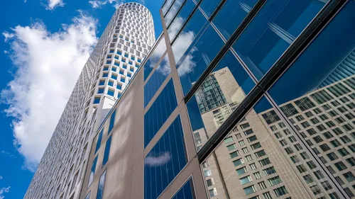 Tilted skyscraper reflected on adjacent building.