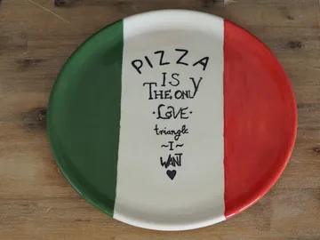 Ein Teller zeigt Pizza-Liebe in italienischen Farben.