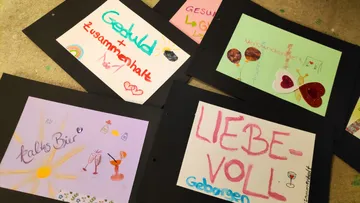 Bunte Karten mit deutschen Wörtern am Boden.