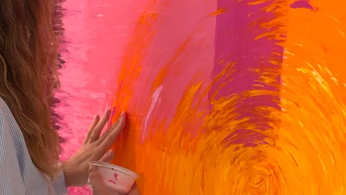 Artist painting vibrant abstract on canvas