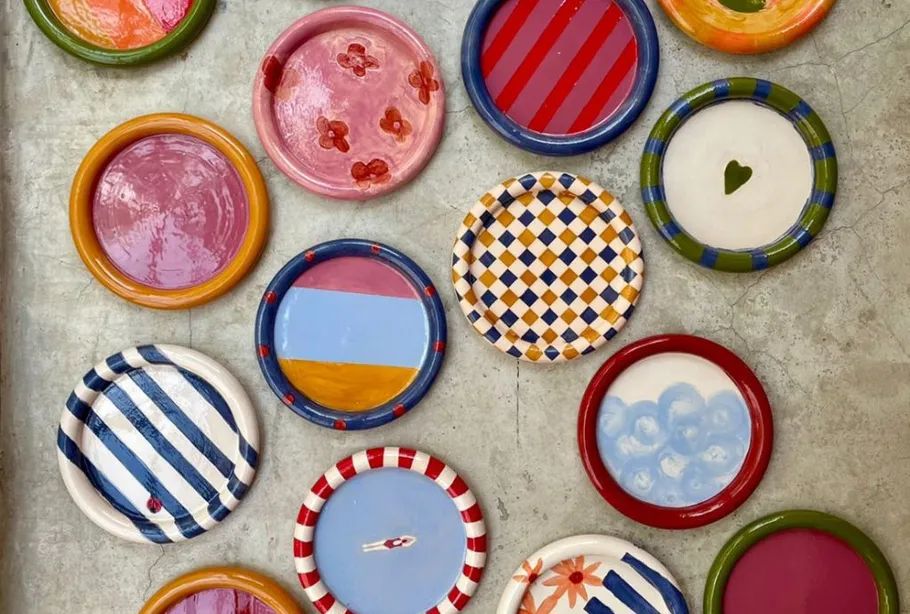 Bunte Keramikteller auf Betonoberfläche.