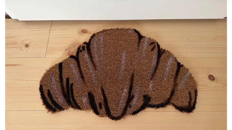 Croissant-förmiger Fußabtreter auf Holzboden.