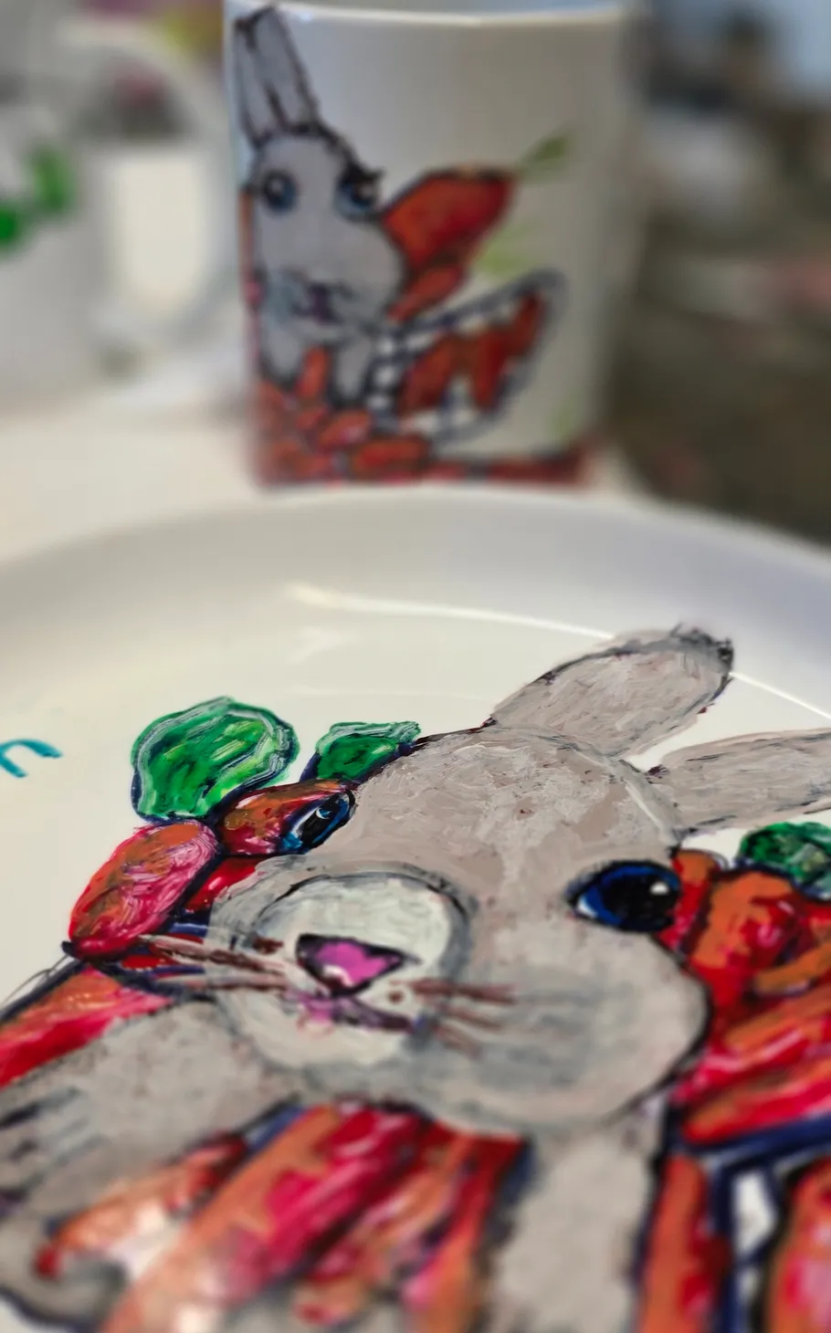 Gemalter Hase auf Teller mit Karotten.