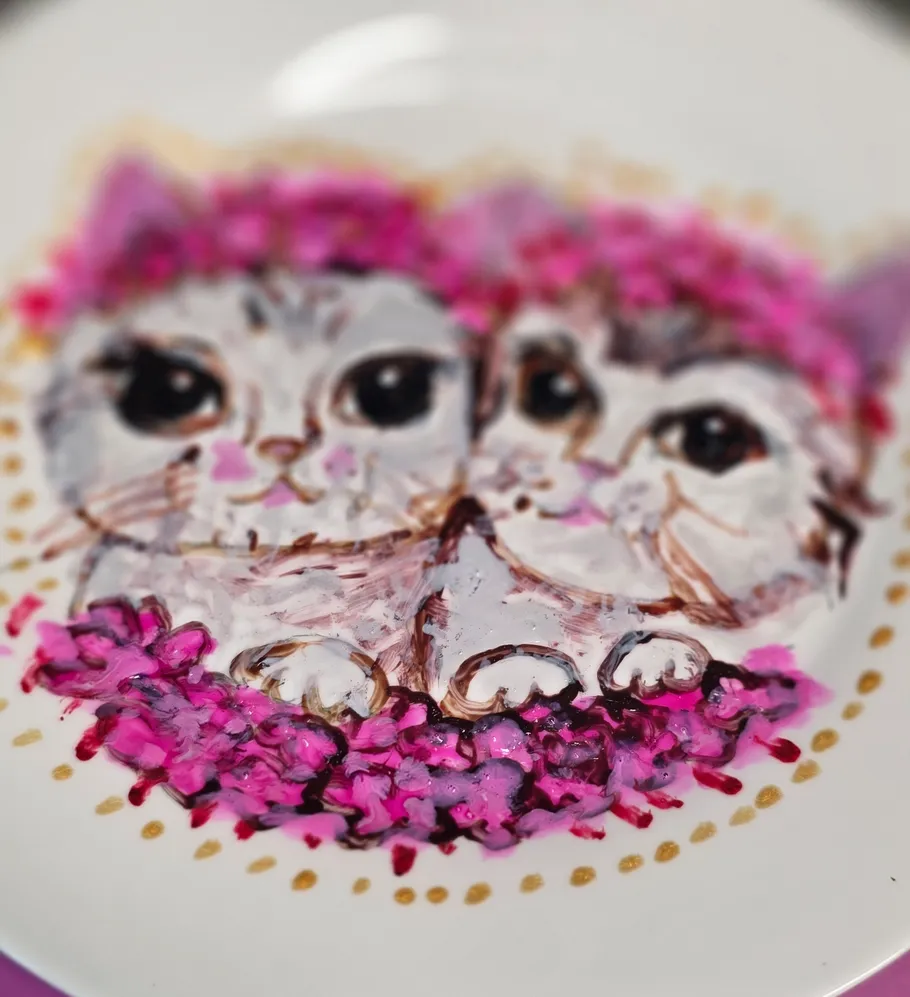 Two painted kittens on a decorative plate.