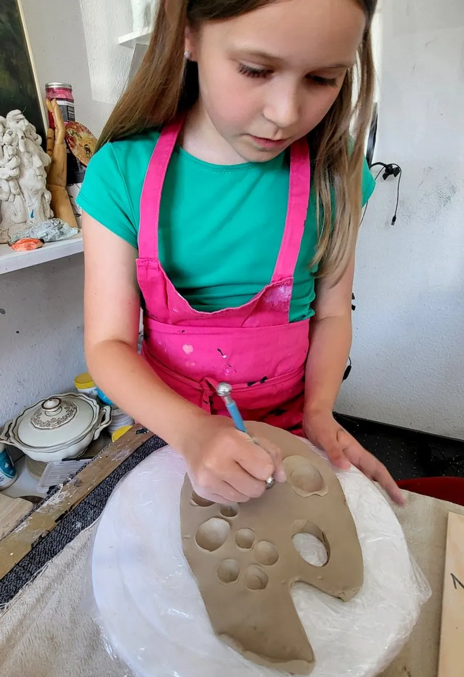 Mädchen töpfert mit Ton im Kunststudio.