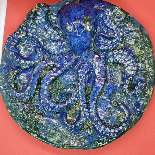 Keramische Oktopus-Kunst auf rotem Hintergrund.