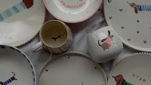 Ceramic plates and mugs with dog illustrations.