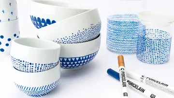 Porzellanschalen mit blauen Mustern und Stiften.