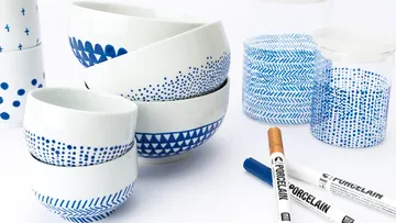 Weiße Schüsseln mit blauen Mustern, Porzellanmarker nahebei.