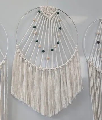 Makramee-Wandbehang mit Perlen, weißer Hintergrund.