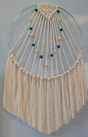 Makramee-Wandbehang mit Perlen an einer Wand.