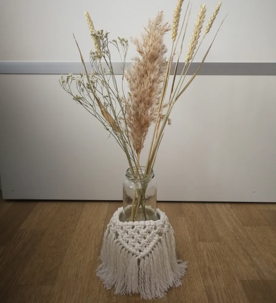 Dried flowers in jar with macrame wrap.