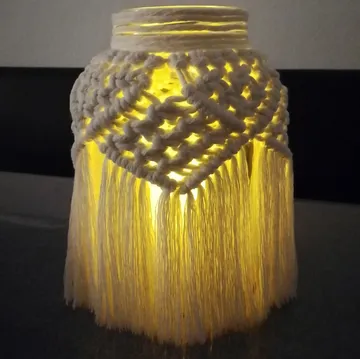 Macrame-covered jar glowing in the dark.