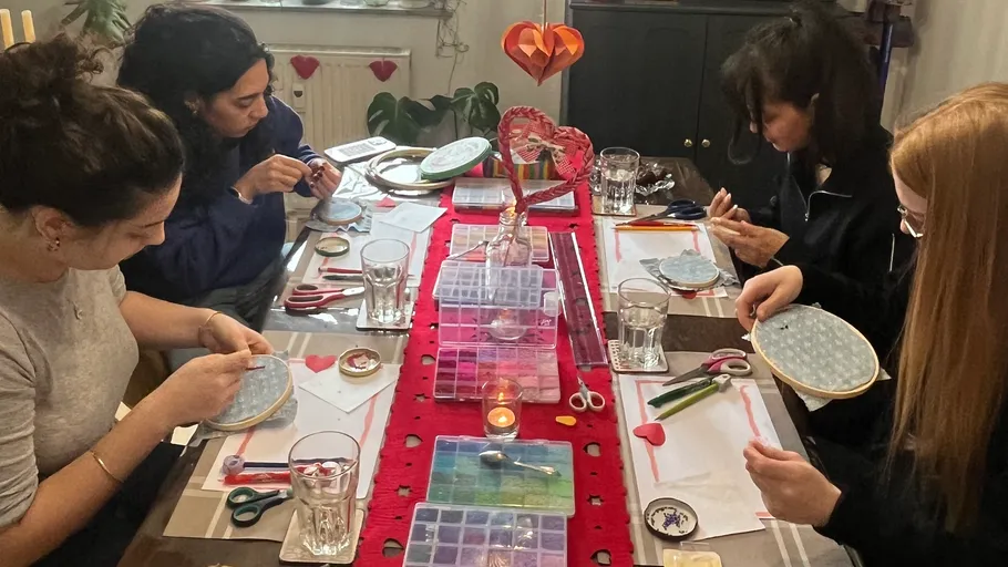 Vier Frauen basteln am Tisch.