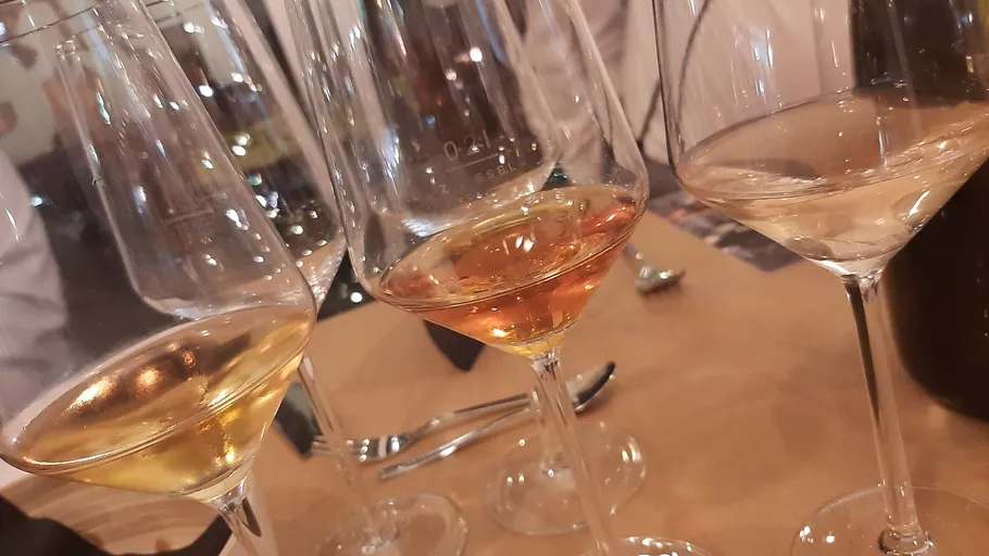 Three wine glasses on wooden table.