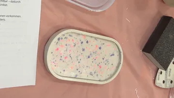 Oval tray with colorful speckles on table.