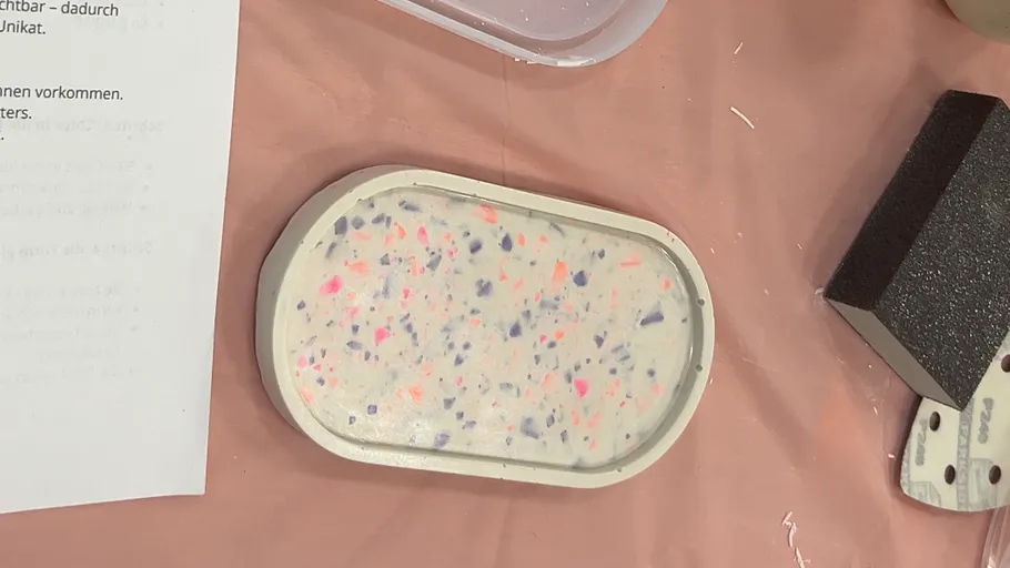 Ovale Schale mit bunten Sprenkeln auf Tisch.