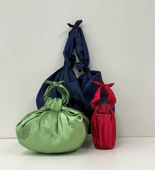 Three fabric-wrapped objects on a surface.