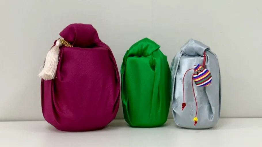Three fabric-wrapped bottles on a shelf.