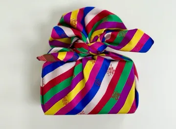 Bunt eingewickeltes Geschenk auf weißem Hintergrund.