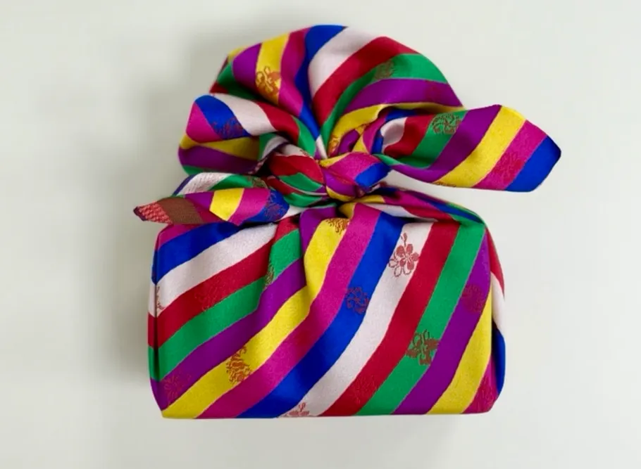 Colorful cloth-wrapped gift on white background.