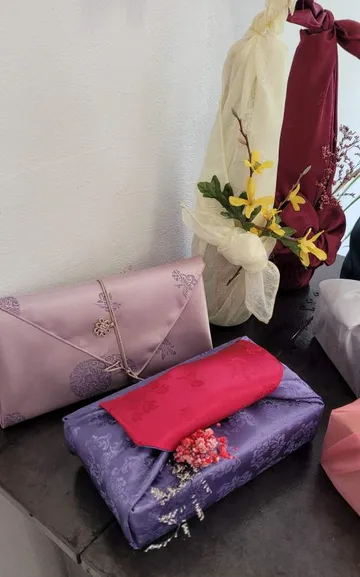 Dekorative Stoffverpackte Geschenke mit Blumenakzenten.