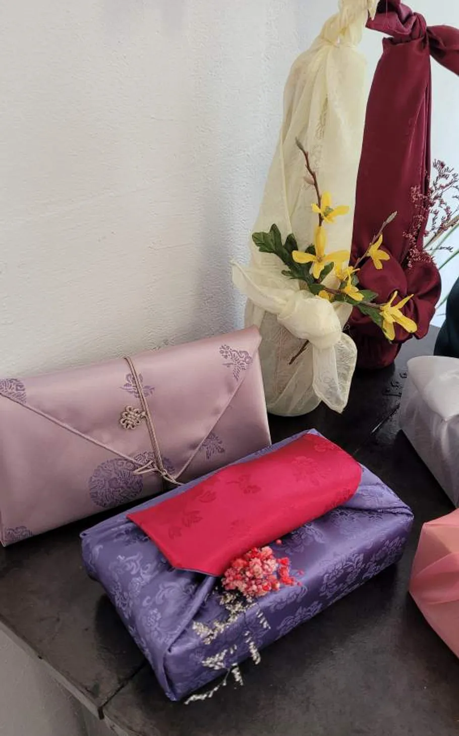 Decorative fabric-wrapped gifts with floral accents.