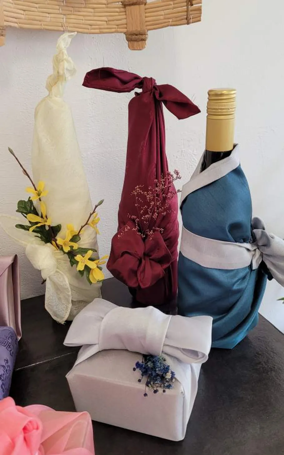 Flaschen in buntem Stoff auf Tisch verpackt.