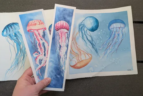 Hand hält Quallen-Aquarelle im Freien.