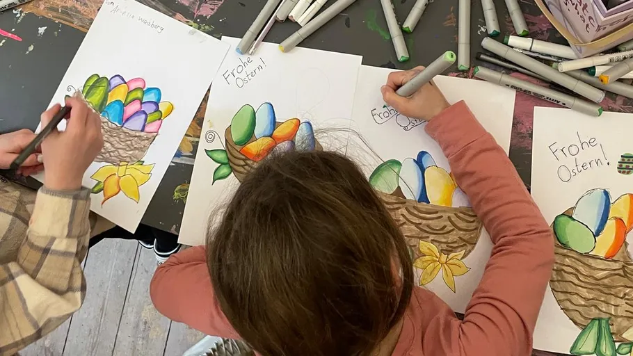 Children coloring Easter basket drawings with markers.