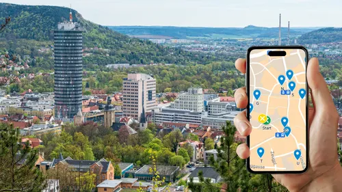 Hand holding phone with city map, cityscape background.