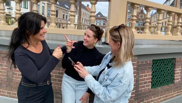 Drei Frauen reden und lachen im Freien.