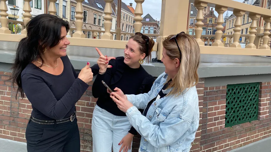 Drei Frauen unterhalten sich fröhlich im Freien in Stadt.