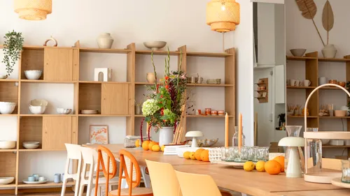 Dining table with chairs and wooden shelves.